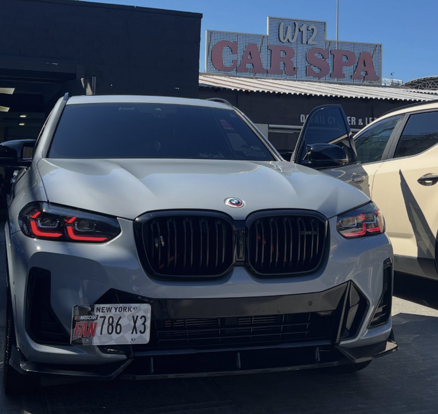 A BMW X3 M40i parked in front of the W12 Car Spa sign and detail center on West 12th Street, Brooklyn
