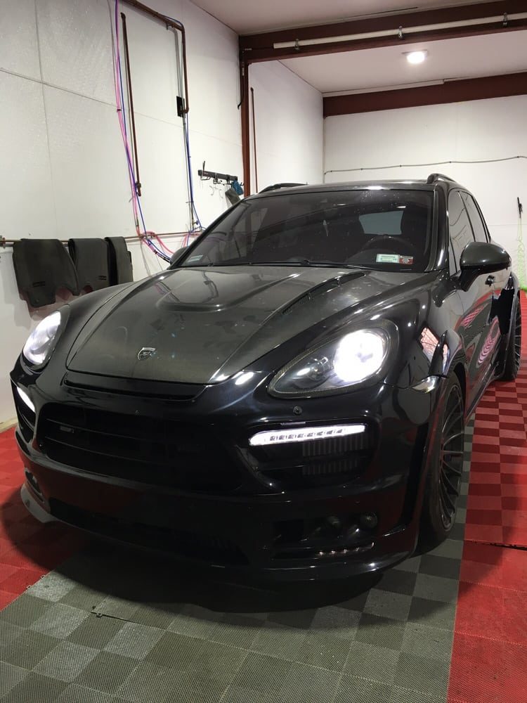 Black Porsche Cayenne on the red shop floor